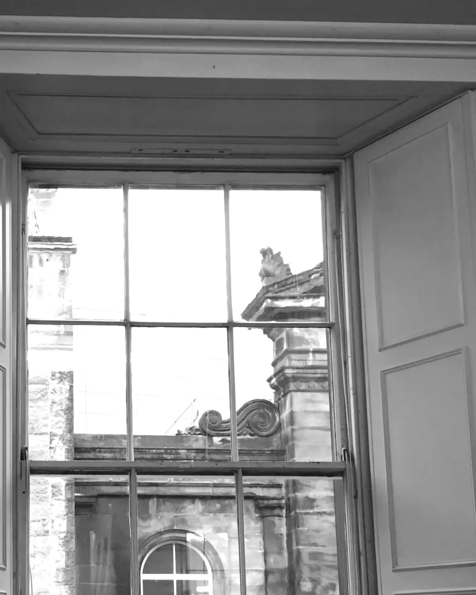 A tall sash window in the Playfair Library, looking out to the stonework of Old College
